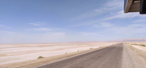 A straight road with the desert on both sides